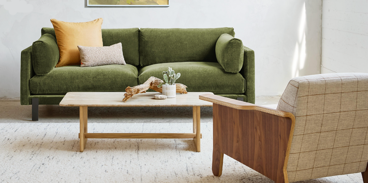 Green sofa with decorative pillows in a living room setting.